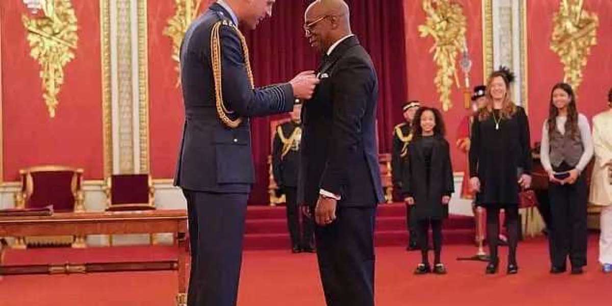 Former England footballer Ian Wright beamed with pride as he was awarded an OBE at an investiture ceremony at Buckingham